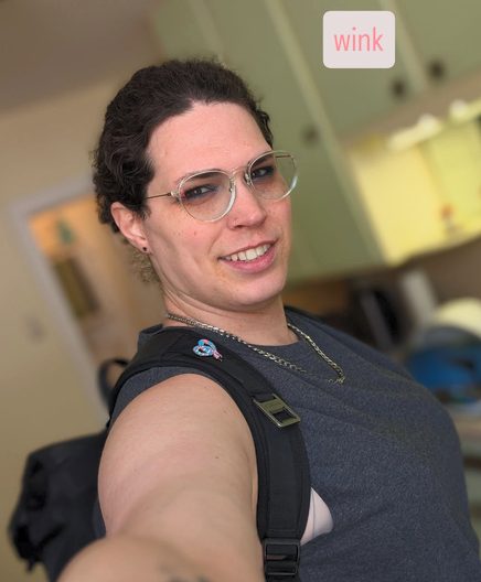 Harper smiling in glasses with a backpack