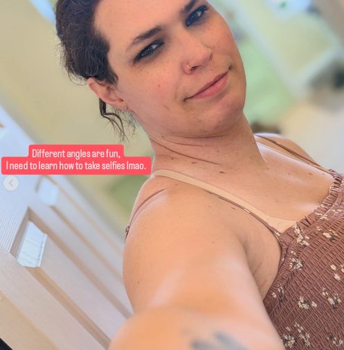 Harper taking a soft-lit selfie in a pink top
