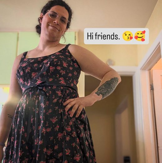 Harper standing in a black floral dress