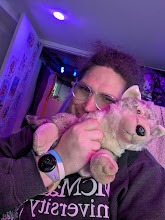 Harper holding Wolfie, her cream-coloured wolf plushie, lit in purple